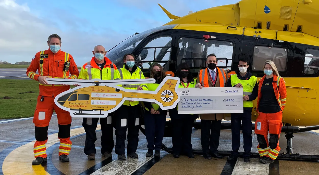 Members of the East Anglian Air Ambulance receiving a cheque for £6990 from Roys Wroxham Food Hall's Store manager and staff