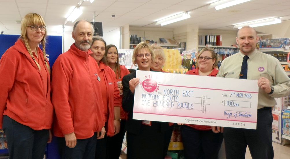 Val Moss, Chair of 1st Holt scouts receiving a cheque on behalf of North East Norfolk District Scouts from staff and Tokia Razzel - manager - of North Walsham store