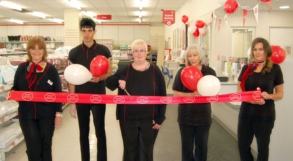 Roys of Magdalen Street Post Office staff cutting the ribbon to open the refitted Post Office counter